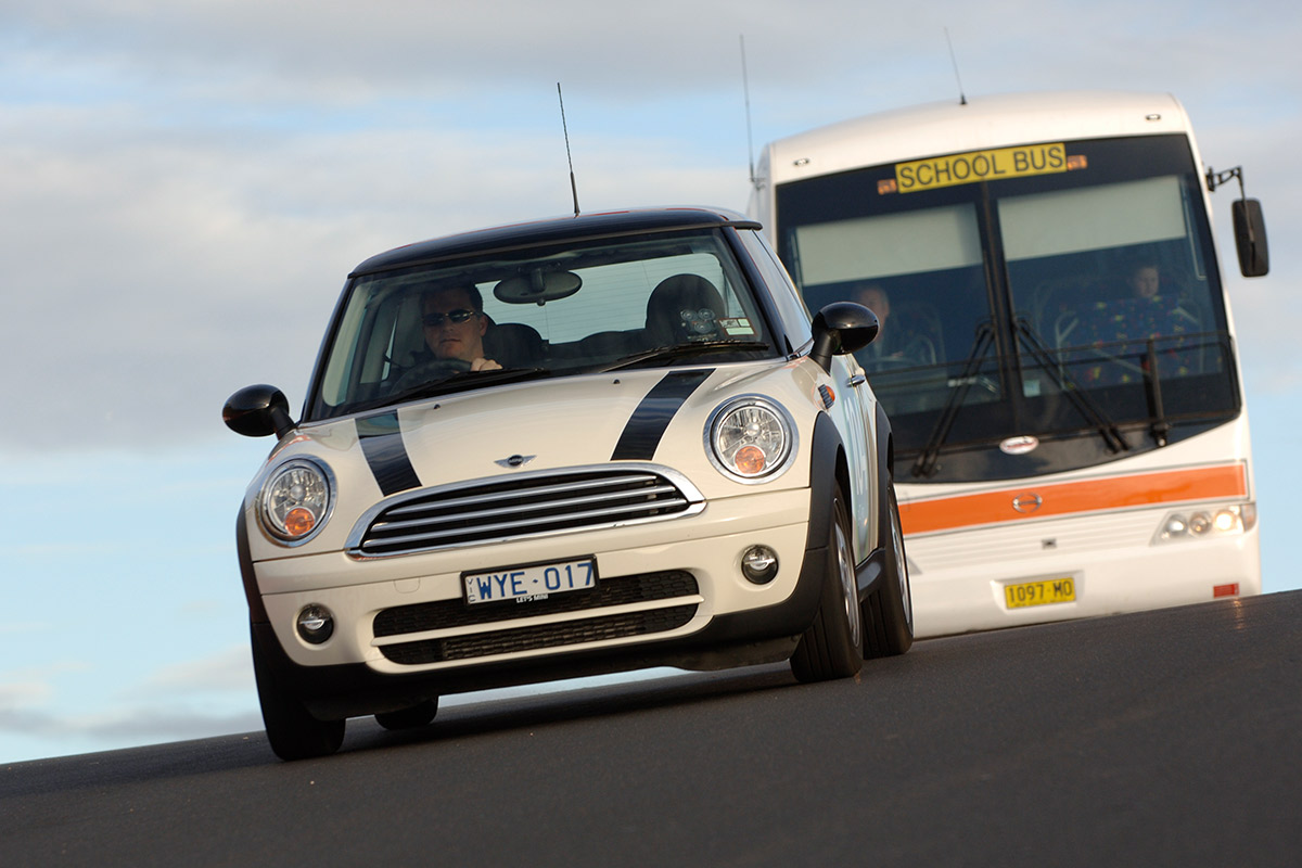 Mini Cooper driving in front of School bus on Mount Panorama Rd.